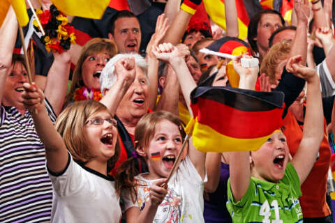 Kinder und Erwachsene jubeln in der Gruppe als Fußballfans