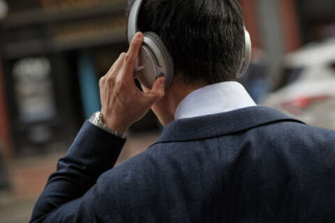 Lärm: Ein Mann steht auf der Straße und richtet einen silbernen Kopfhörer aus