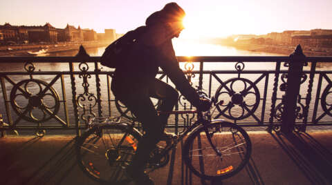 Radfahren: Mann fährt mit Fahrrad über Brücke