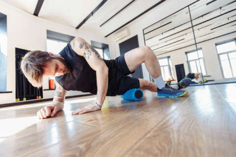 Faszientraining: Ein Mann trainiert seinen Oberschenkel auf einer Faszienrolle