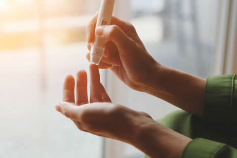 Diabetes: Eine Frau prüft ihren Blutzuckerwert mit einem Messgerät am Finger.