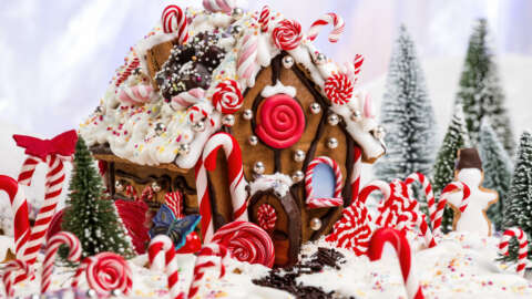 Weniger Zucker: Rotes Lebkuchenhaus mit roten Süssigkeiten