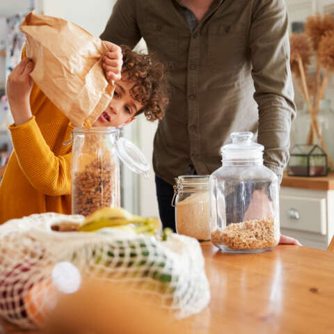 Earth Day: Der Sohn füllt mit seinem Vater Lebensmittel in Gläser
